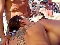 Two girls suck a cock on a beach and get cum on their tits