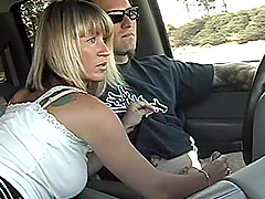 Blonde milf toys her pussy in a car and gives hand to her man