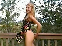 Blonde with long hair lifts up her dress and shows her thong