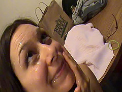 Ponytailed brunette in glasses provides a cute blowjob through a gloryhole