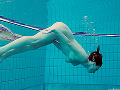 Ravishing redhead babe with a nice ass strips down underwater